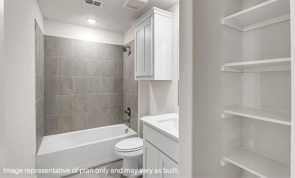 Full bathroom with tiled shower / bath combo, toilet, and vanity