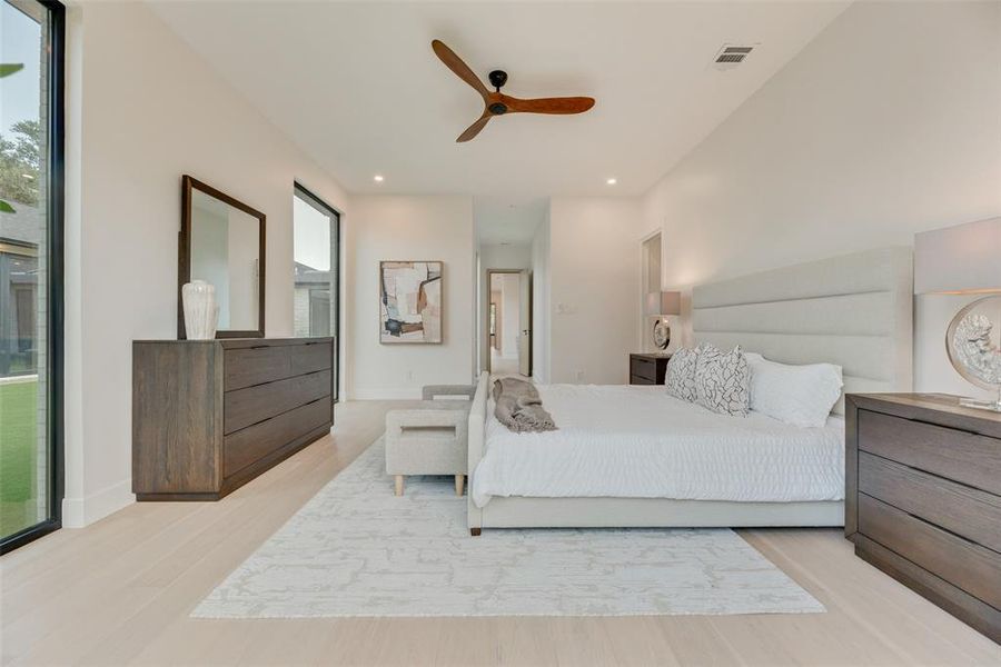 Bedroom featuring ceiling fan, light hardwood / wood-style flooring, and multiple windows