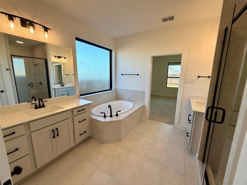 This bathroom showcases a relaxing soaking tub and sleek walk-in shower. Together, they create a serene and spa-lieke retreat.