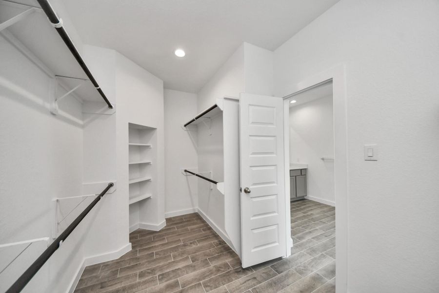 Walk-in closet that epitomizes luxury and practicality. This generously sized space features built-in shelving, offering abundant room for impeccable organization. High ceilings and recessed lighting create a bright and welcoming ambiance. Walk-in closet that epitomizes luxury and practicality. This generously sized space features built-in shelving, offering abundant room for impeccable organization. High ceilings and recessed lighting create a bright and welcoming ambiance.