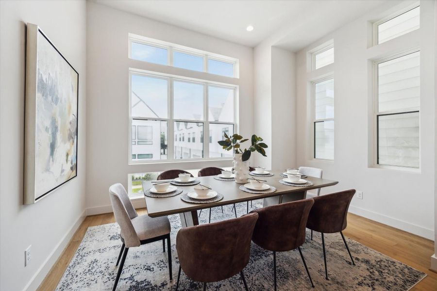 Bright and airy dining room with large windows, modern decor, and a stylish table set for six. Perfect for entertaining.