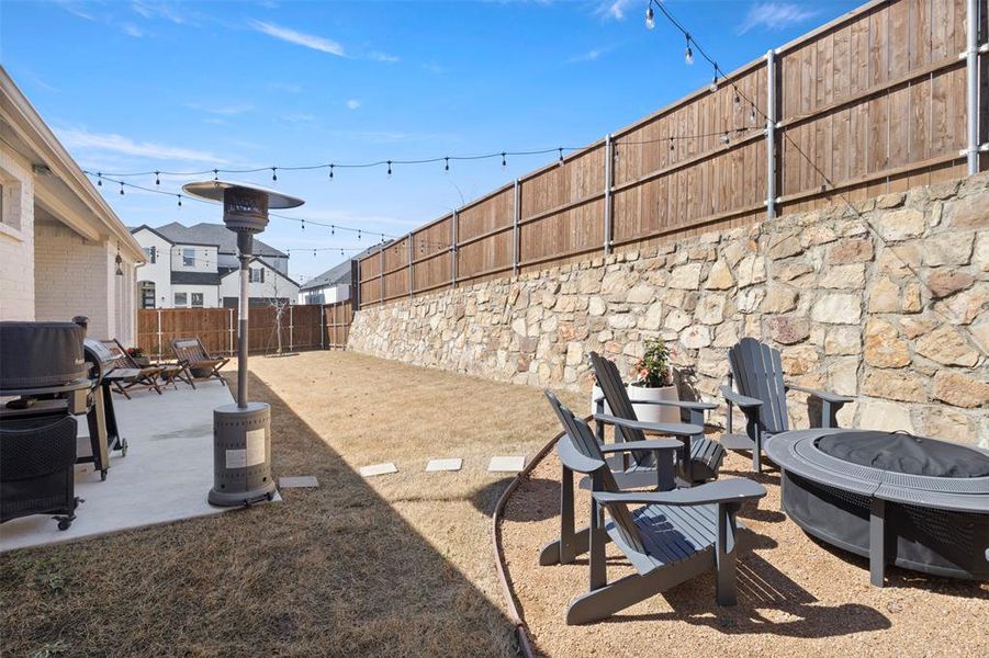 View of yard featuring a patio, fireplace, and hanging lights