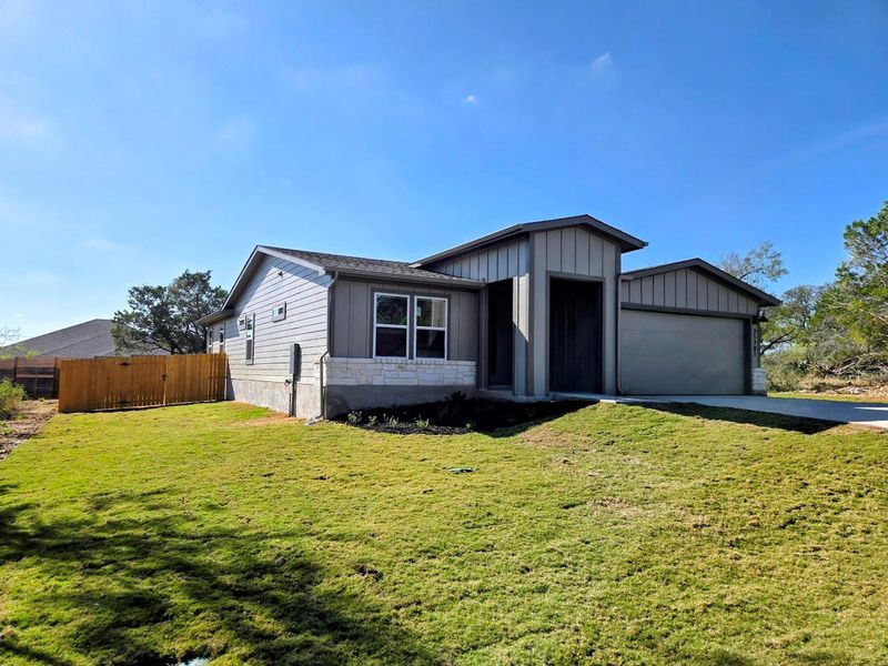 View of front facade with board and batten siding, a garage, and concrete driveway View of front facade with board and batten siding, a garage, and concrete driveway