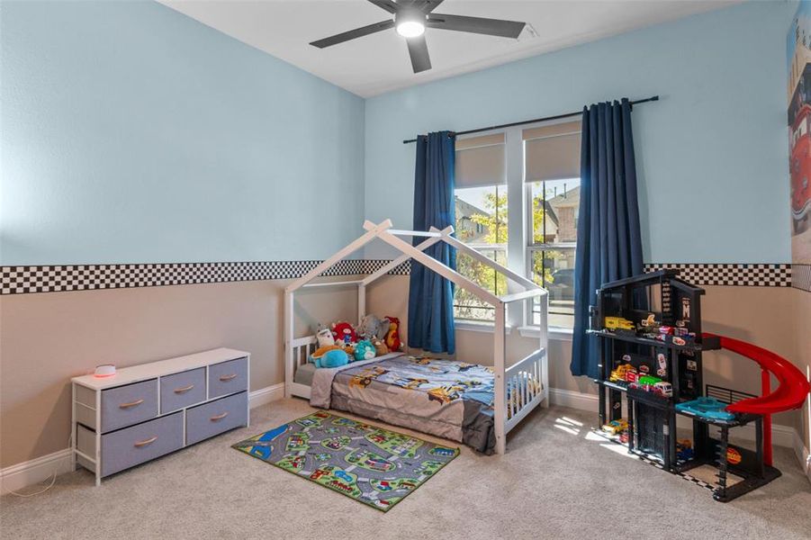 Bedroom with light carpet and a ceiling fan