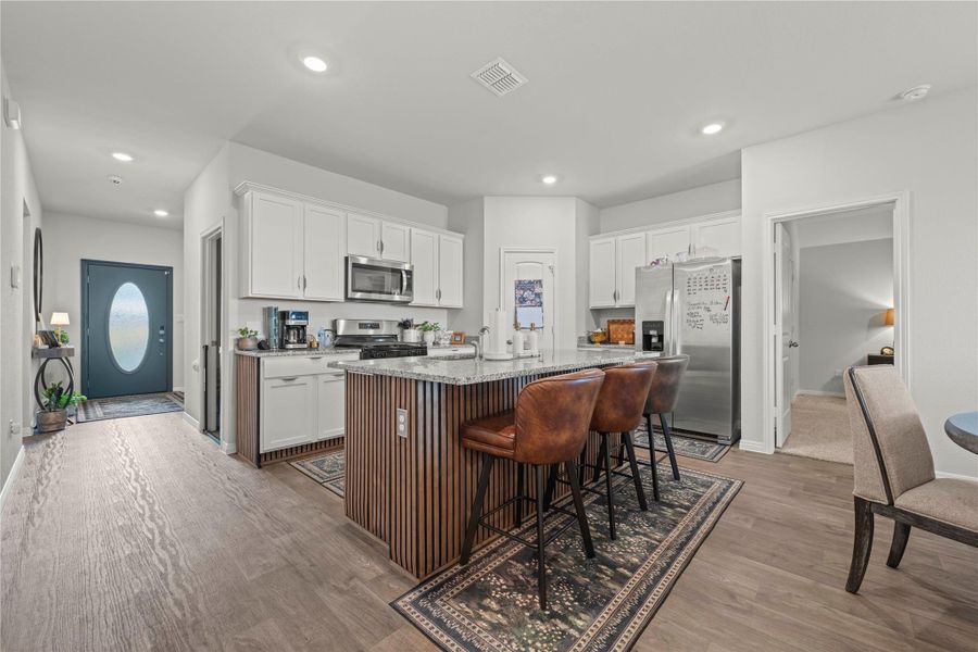 A well-appointed kitchen island with bar seating anchors this bright, open-concept living space.