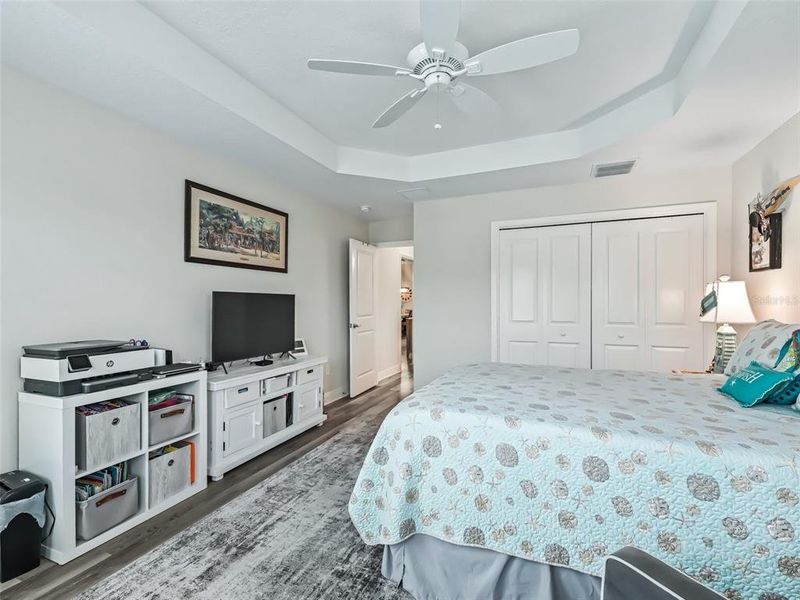 Front bedroom with coffered ceiling, bay windows, and plantation shutters