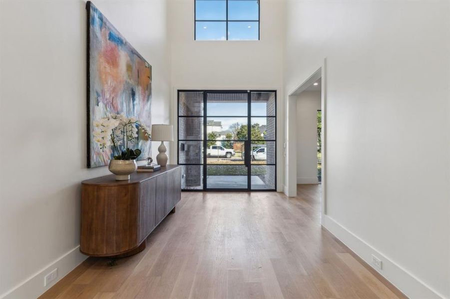 Foyer entrance with a towering ceiling and light hardwood / wood-style floors