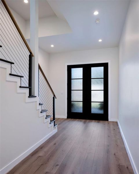 Foyer entrance with light wood-type flooring and french doors