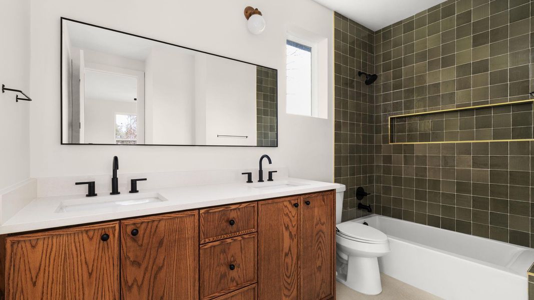 Full bathroom with double vanity and shower / bath combination