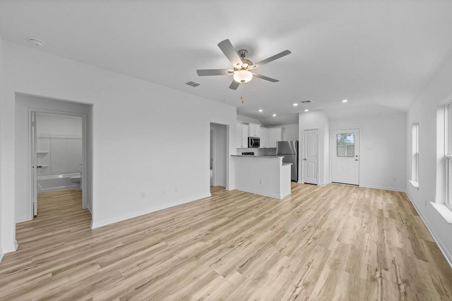 Gleaming wood-look floors anchor a light-filled open layout that seamlessly connects to the kitchen.