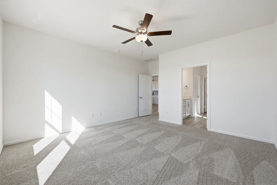 Unfurnished bedroom with a ceiling fan, light carpet, and ensuite bathroom