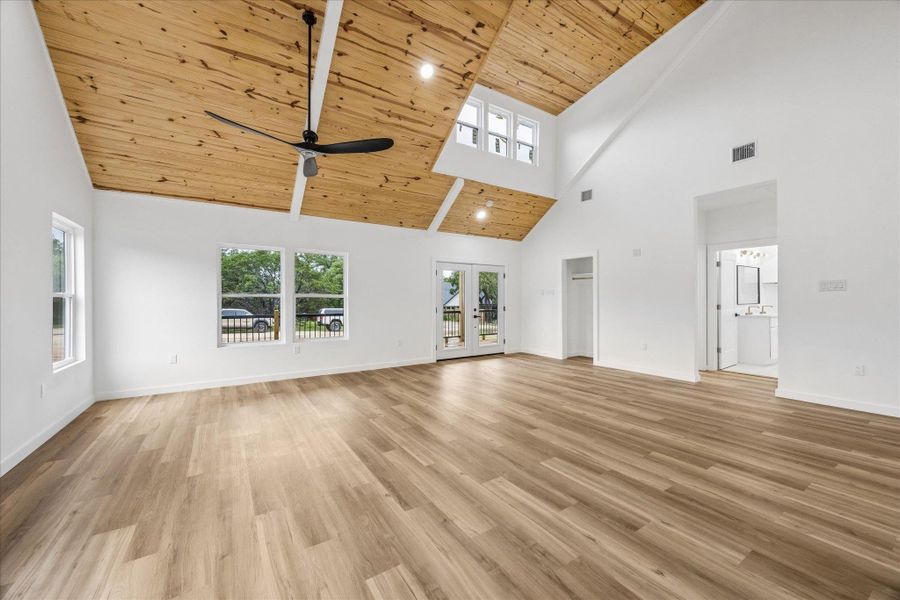 A spacious living area with vaulted wooden ceilings and large windows creates an open, airy atmosphere. A spacious living area with vaulted wooden ceilings and large windows creates an open, airy atmosphere.
