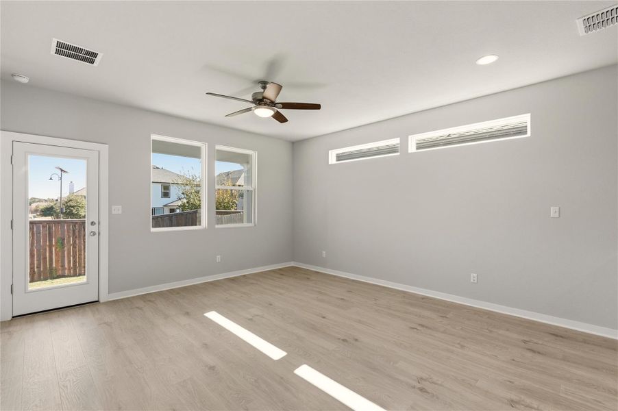 Empty room featuring light wood-style flooring and ceiling fan