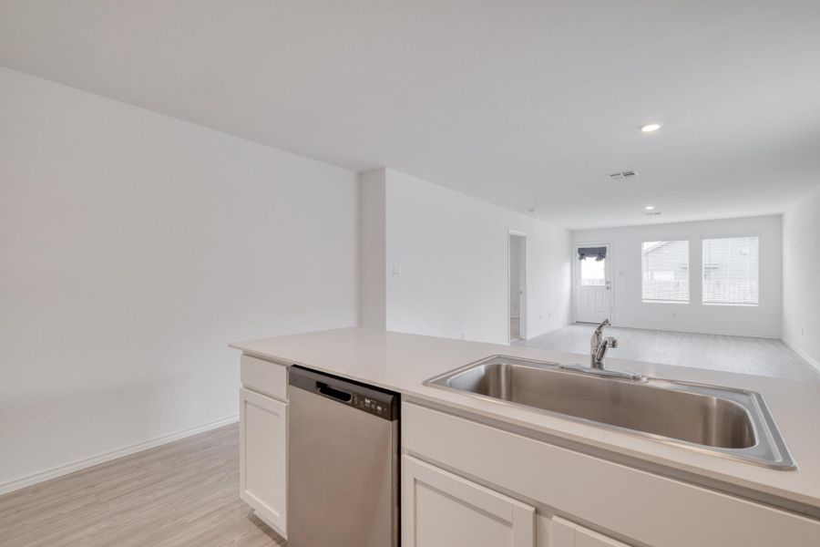 Kitchen island with an undermount stainless steel sink, a chrome faucet, and integrated stainless steel dishwasher