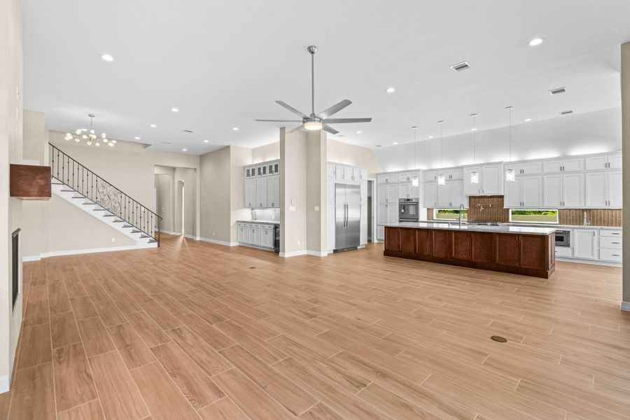 Open transition from kitchen to living area with large windows and an inviting atmosphere perfect for gatherings.
