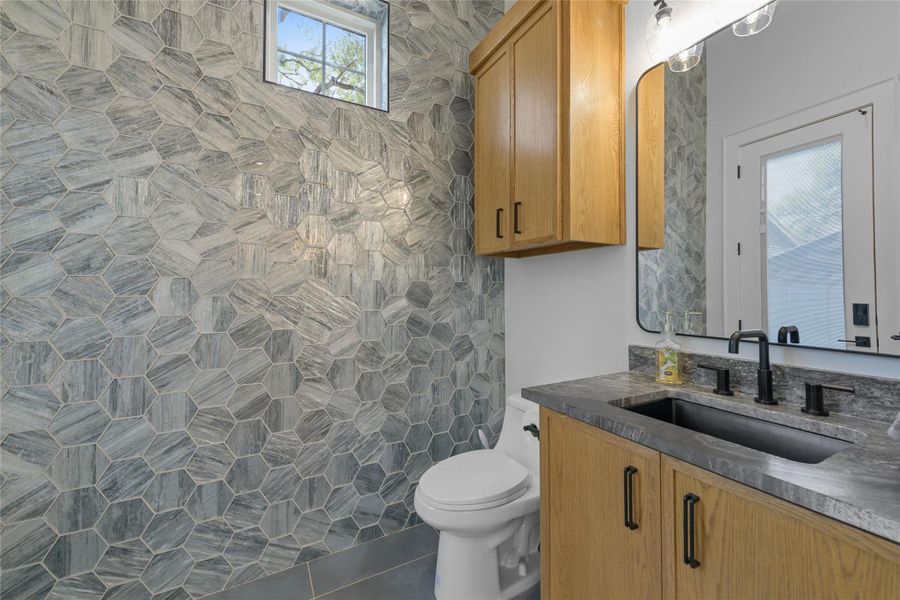 Elegant half bathroom located downstairs, which also has direct access from outside as a pool bathroom.