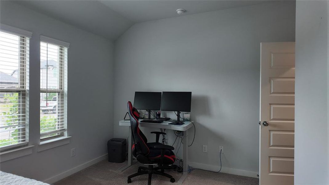 This room features two windows with blinds, a neutral wall color, and carpeted flooring