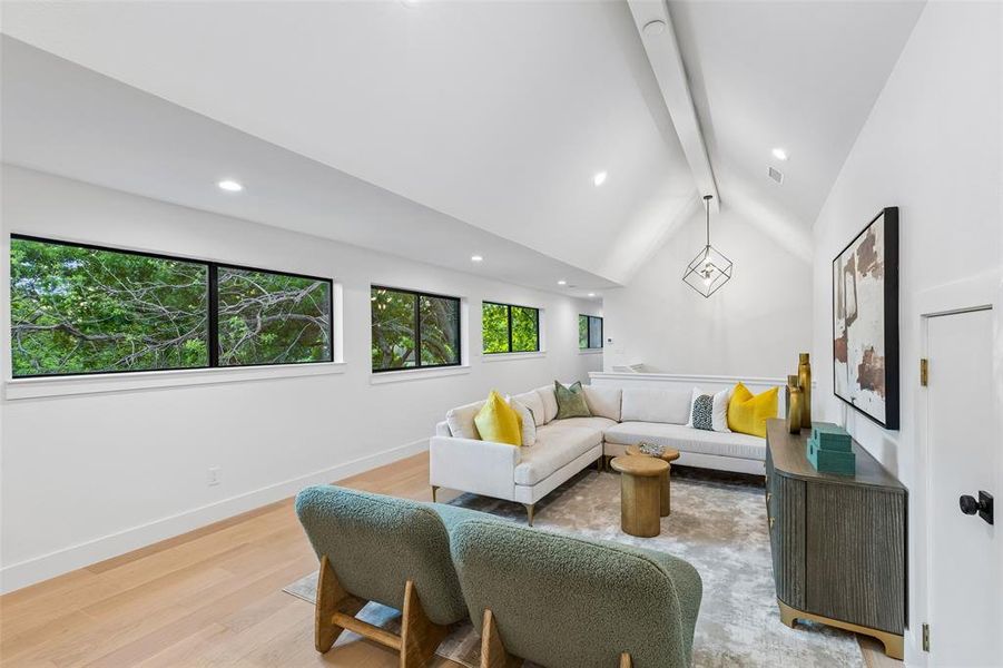 Versatile bonus room with vaulted ceilings and abundant natural light, perfect for a game room, media space, or additional living area.