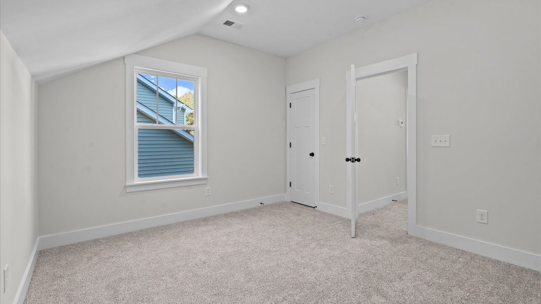 Highly functional bedroom with large windows, carpeted flooring, and tasteful finishes throughout Highly functional bedroom with large windows, carpeted flooring, and tasteful finishes throughout