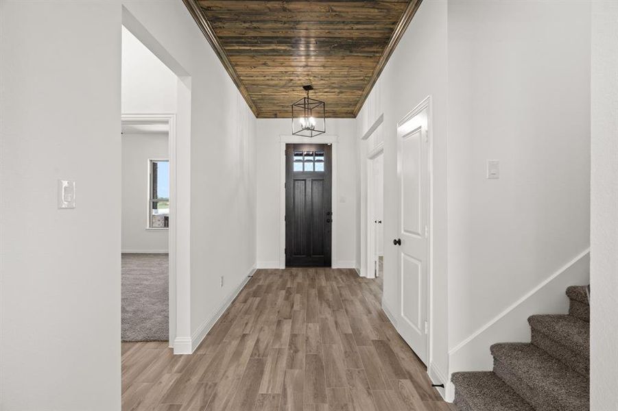Foyer entrance featuring wood ceiling, light wood-style floors, plenty of natural light, and stairway Foyer entrance featuring wood ceiling, light wood-style floors, plenty of natural light, and stairway