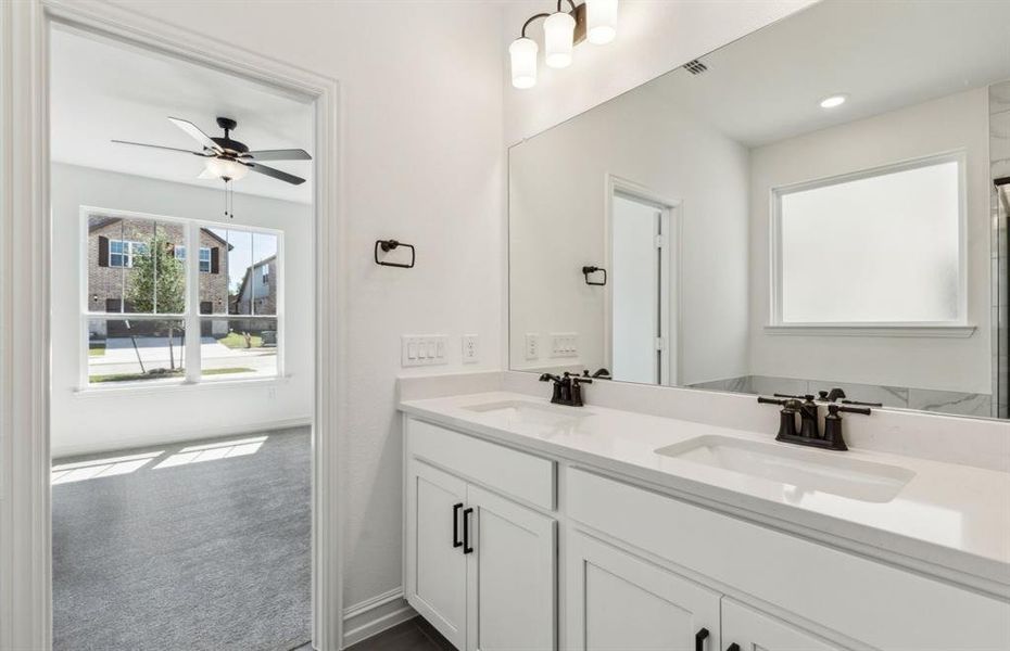 Modern owner's bath with dual vanities and a spacious shower *Real home pictured