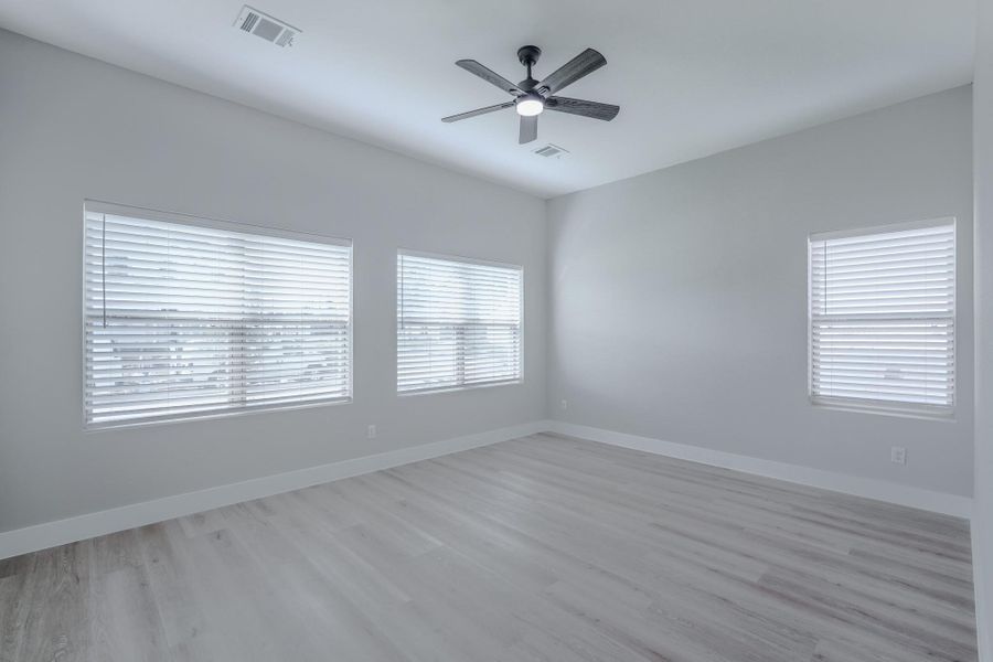 Primary suite retreat with large windows and serene backyard views