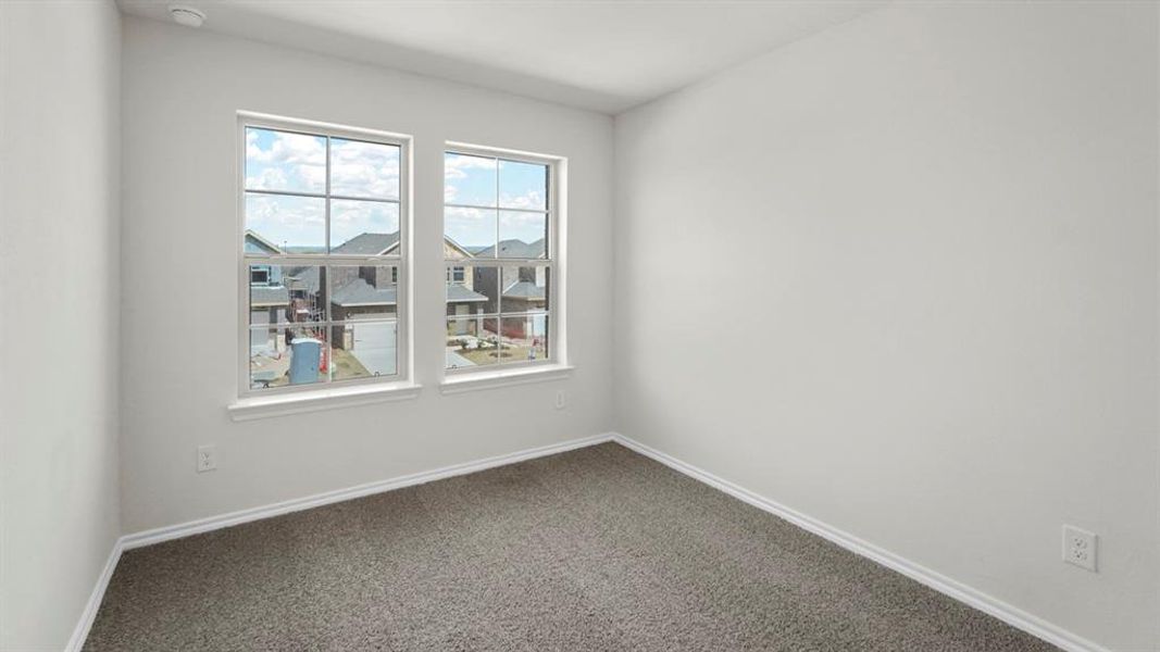 This room features two windows and soft gray carpeting