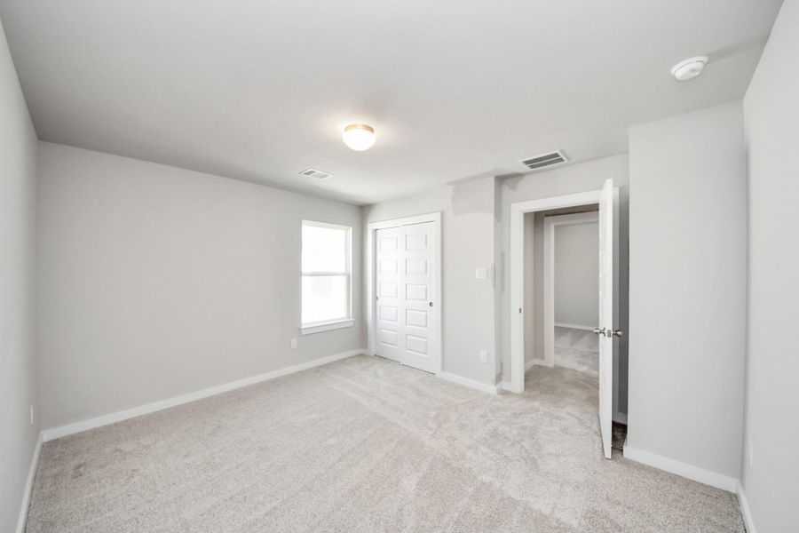 Generously sized secondary bedrooms featuring spacious closets, soft and inviting carpeting underfoot, large windows allowing plenty of natural light, and the added touch of privacy blinds for your personal retreat. Sample photo of completed home with similar floor plan. Actual colors and selections may vary.