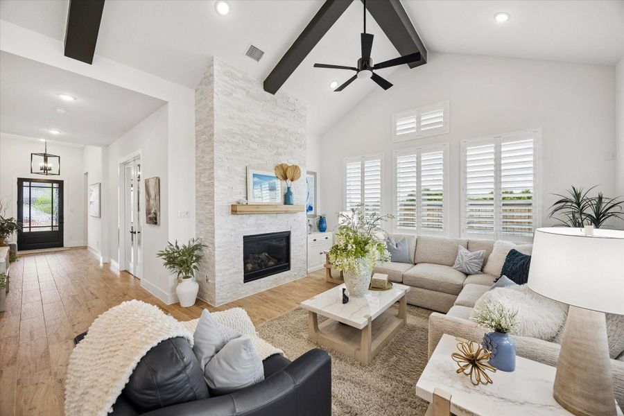 Vaulted family room featuring upgraded decorative beams, recessed lighting, and custom plantation shutters.