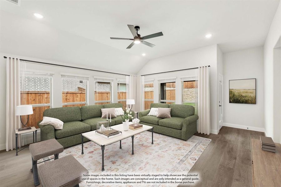 Living room with vaulted ceiling, ceiling fan, two green sofas, hardwood floors, and large windows with backyard views. Living room with vaulted ceiling, ceiling fan, two green sofas, hardwood floors, and large windows with backyard views.