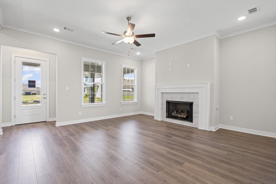 Unfurnished living room with crown molding, Revwood finished floors, gas fireplace, recessed lighting, and ceiling fan