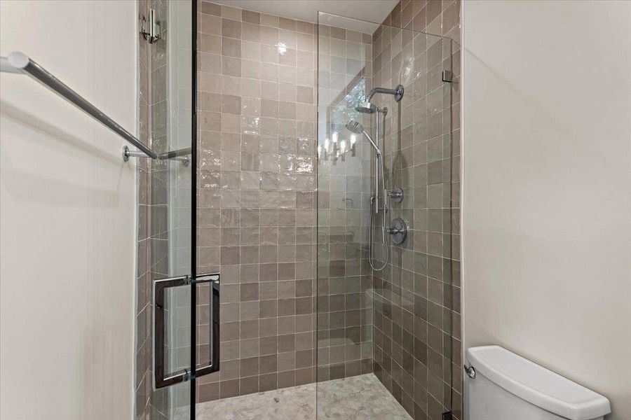 A well-appointed shower features sleek glass enclosure and contemporary tiling. A well-appointed shower features sleek glass enclosure and contemporary tiling.