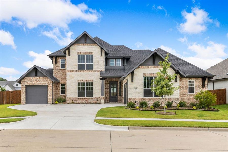 View of front of house with a garage and a front yard