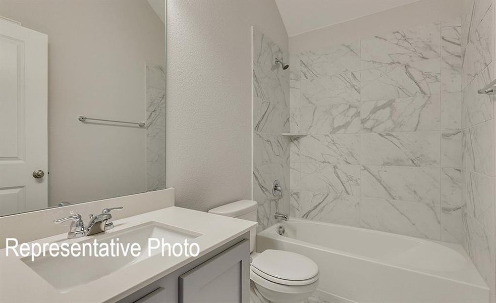 Full bathroom featuring tiled shower / bath combo, vanity, and toilet