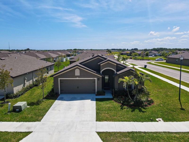 Front exterior of a new home in Celebration Pointe, Fort Pierce, FL, highlighting curb appeal (Image 22).