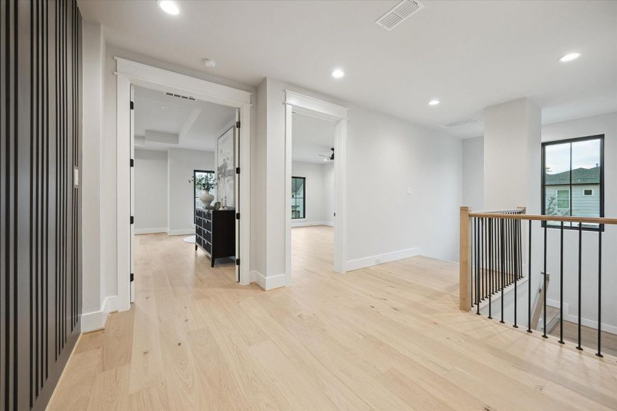 Landing at the top of the stairs with the flex room on the right and primary bedroom through the double doors on the left.