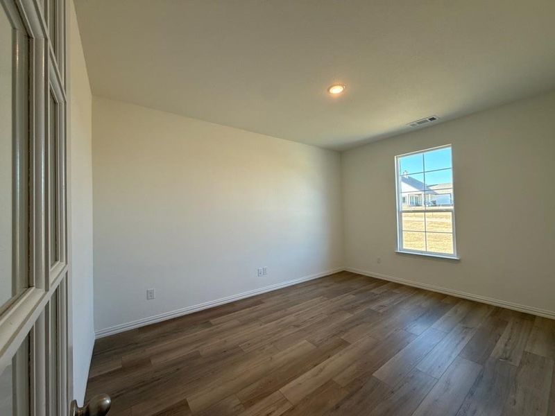 Empty room featuring wood finished floors and recessed lighting
