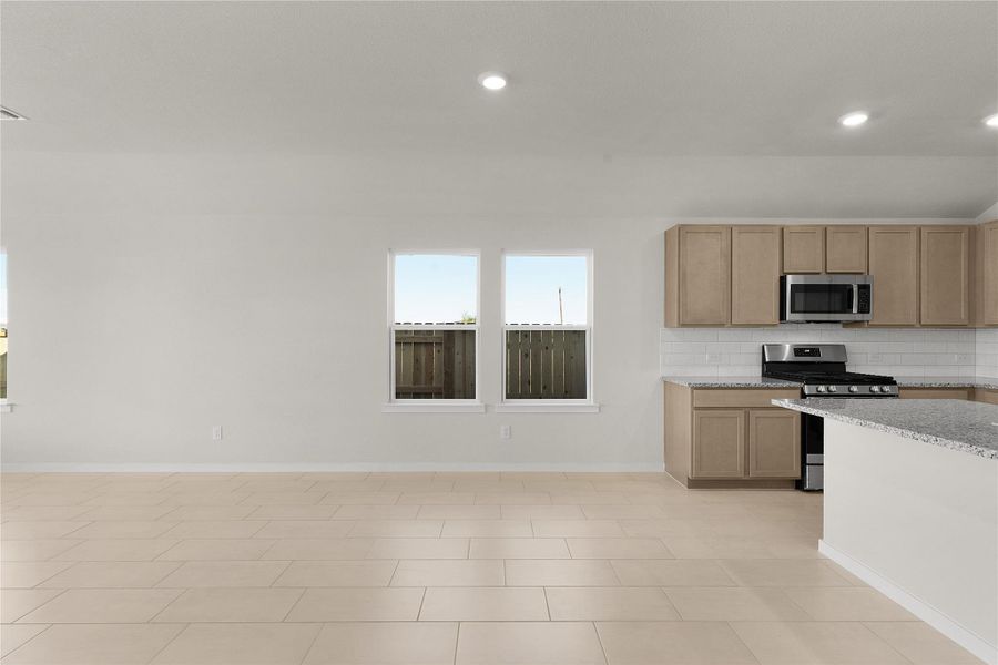 Kitchen featuring stainless steel appliances, light stone counters, tasteful backsplash, and recessed lighting
