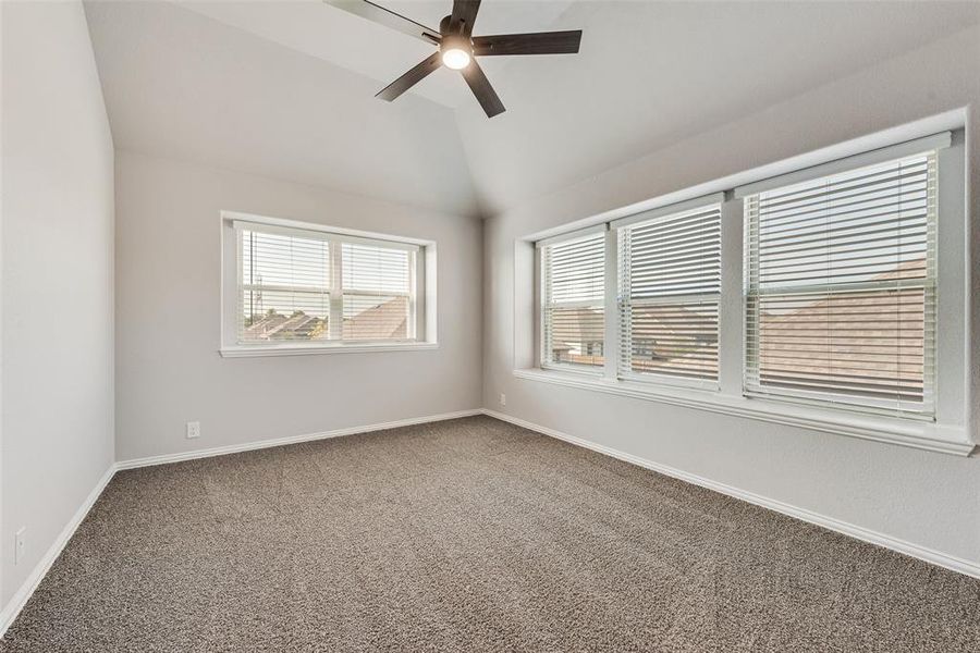 Spare room with carpet flooring, lofted ceiling, and ceiling fan Spare room with carpet flooring, lofted ceiling, and ceiling fan