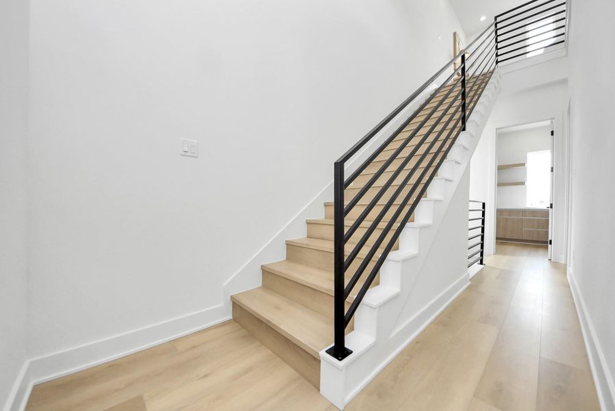 Modern staircase leading to the fourth-floor living space and rooftop terrace.