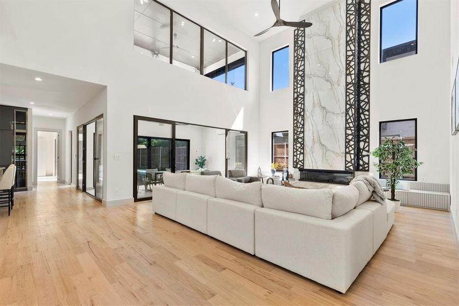 Living room featuring light wood-type flooring and a towering ceiling