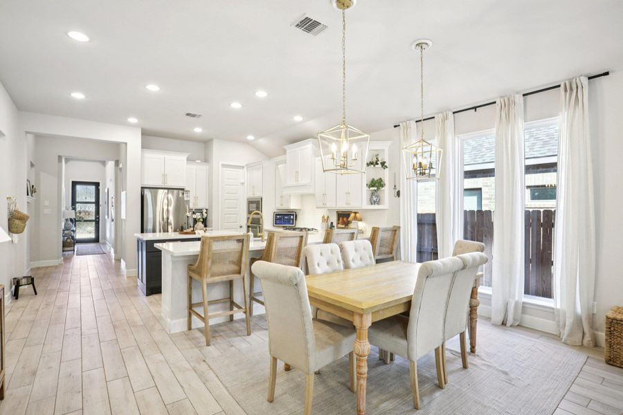 Dining area featuring wood tiled floors, suspended lighting, and healthy amount of natural light