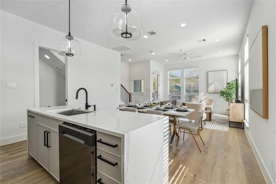 Another view of the kitchen overlooking the dining and living room area showcasing the functional design of the home.