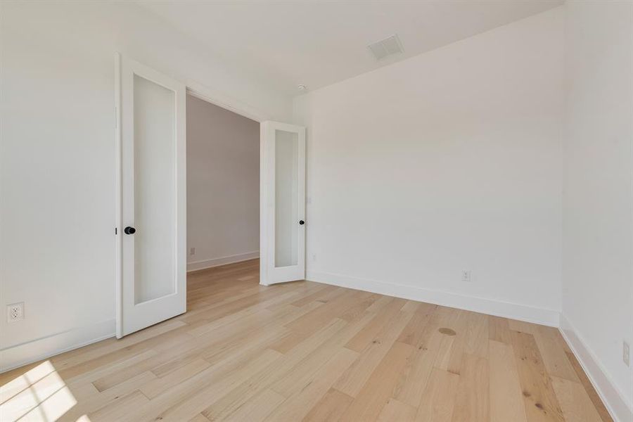 Unfurnished room featuring light wood-style floors and french doors