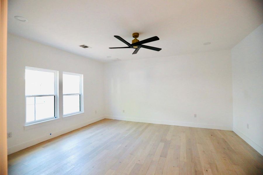Spare room with light wood finished floors and ceiling fan
