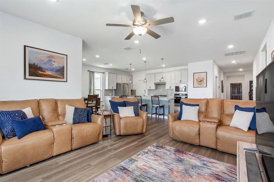 Living area with light wood finished floors, a ceiling fan, and recessed lighting