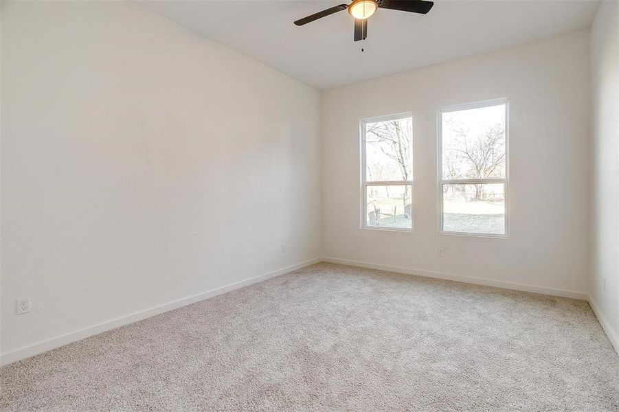 Unfurnished room with ceiling fan and carpet