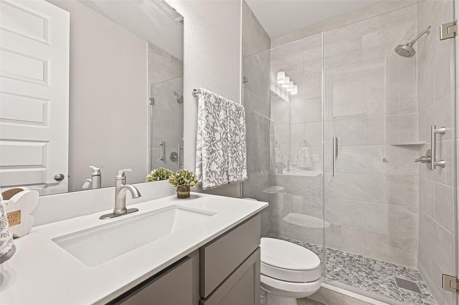 Full bathroom situated between two secondary bedrooms, featuring an upgraded shower and brushed nickel fixtures. (Note: Photo is staged; property is currently vacant.) Full bathroom situated between two secondary bedrooms, featuring an upgraded shower and brushed nickel fixtures. (Note: Photo is staged; property is currently vacant.)