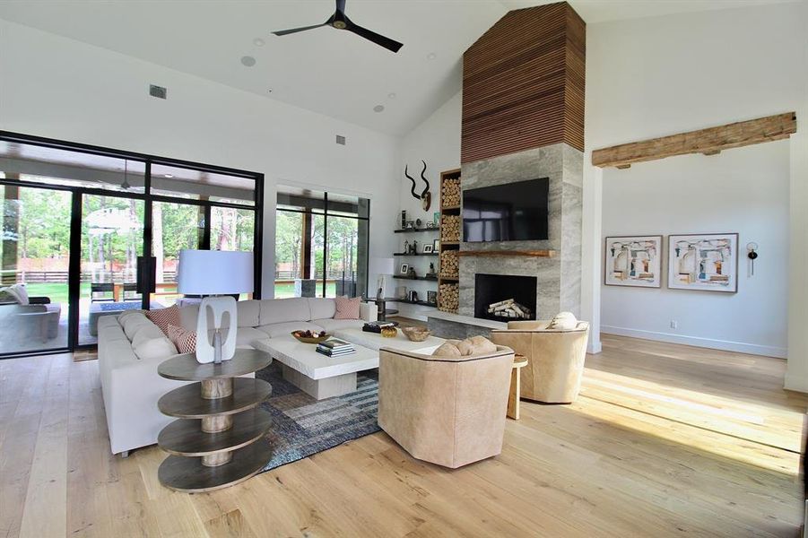 This luxurious living room features high ceilings, a remarkable fireplace, and great views of the backyard oasis!