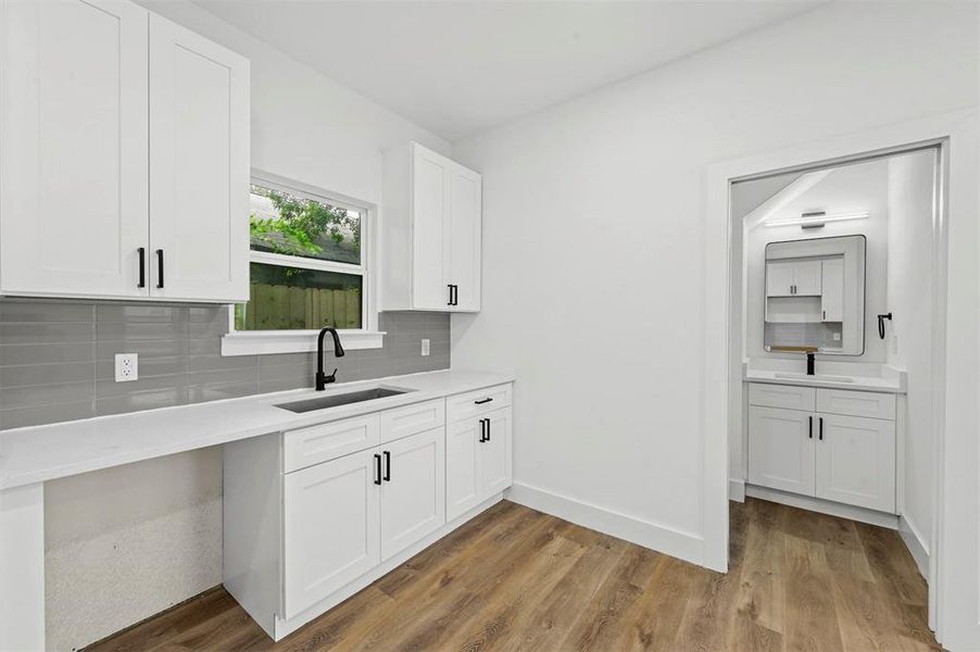 Kitchen featuring light hardwood / wood-style floors, sink, and white cabinets